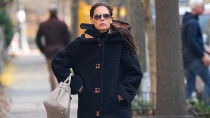 Katie Holmes walking in New York City wearing a duffle teddy coat and the sock boot trend