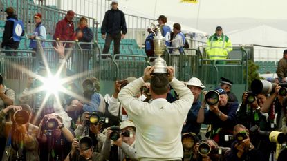 Todd Hamilton faces the photographers while holding the Claret Jug above his head