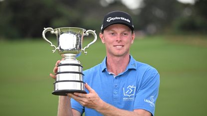 Ryggs Johnston holds up the Australian Open trophy after winning in 2024