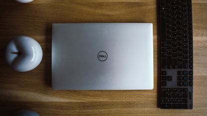 Best Dell laptops: Image depicts silver Dell laptop closed on desk, next to keyboard