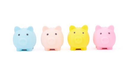 Four piggy banks in different colors against a white background. 