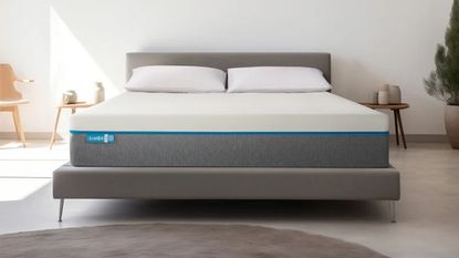 A render of the Simba Hybrid Original mattress on a grey upholstered bed in a bedroom