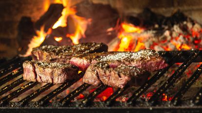 flaming barbecue grill with steaks