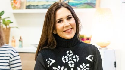 Queen Mary of Denmark, wearing a festive knitted vest, attends the WeShelter Food Club Event at NABO Center Amager on December 17, 2024