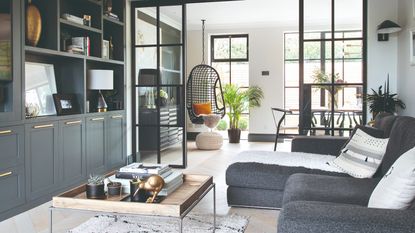 A living room with a built-in media unit in dark grey and a matching chaise sofa opposite 