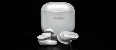 Bose QuietComfort Ultra Earbuds loose earbuds in front of case with black background.