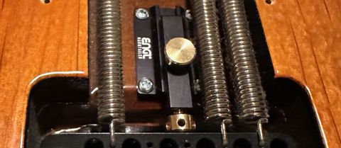 When engaged, the Hardtailer (installed here on a Ernie Ball Music Man Cutlass) prevents a “floating” trem block from pulling sharp, allowing you detune or change one or more strings without the other strings going out of tune.