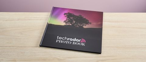 The Mixbook photo book sits on a light wooden surface.