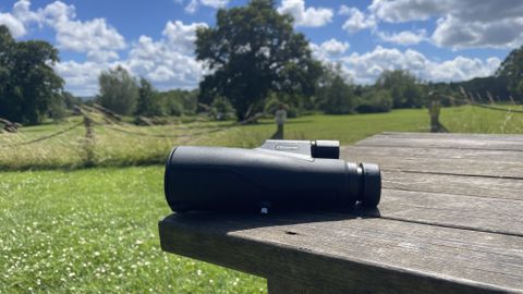 Python 12x52 Range Master Ultra HD Monocular on a wooden table in a park