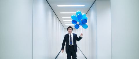 Mark S holding a bunch of blue balloons in a white hallway in Severance season 2