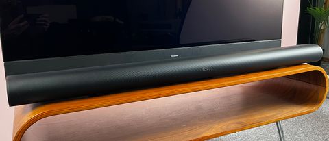 Sonos Arc Ultra in front of a TV, on a wooden table