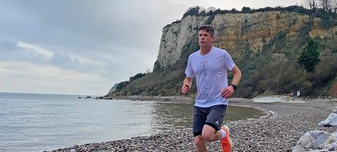 Male runner wearing adidas Terrex Agravic Trail Running t-Shirt on a pebbly beach