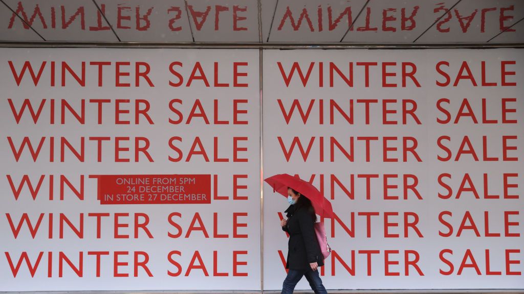 A pedestrian walks past a winter sale sign