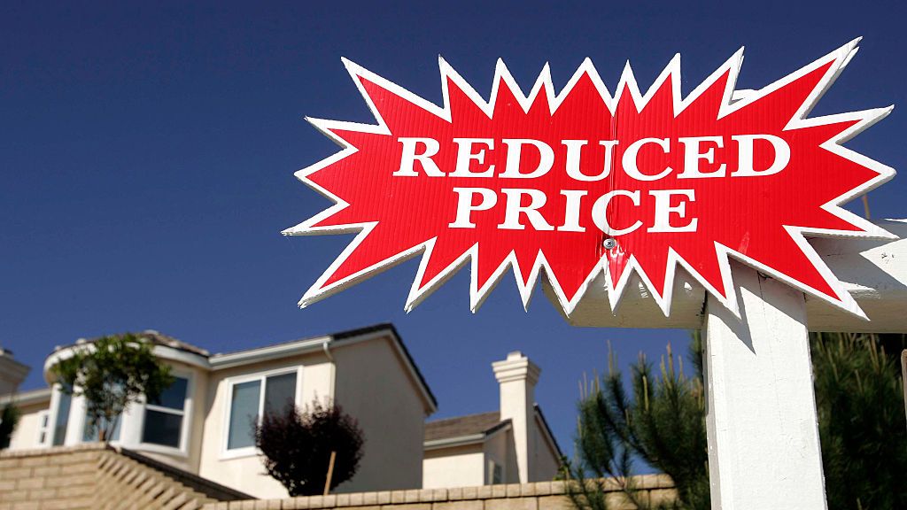 Sign indicates a price reduction of a home for sale