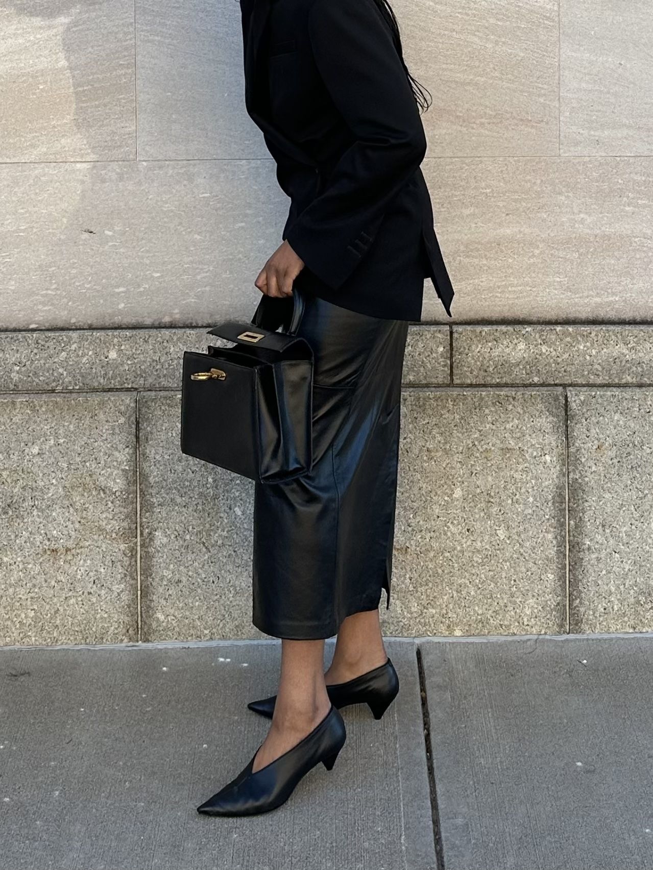 Maya Moore styles high vamp heels with a black leather skirt, sweater and briefcase