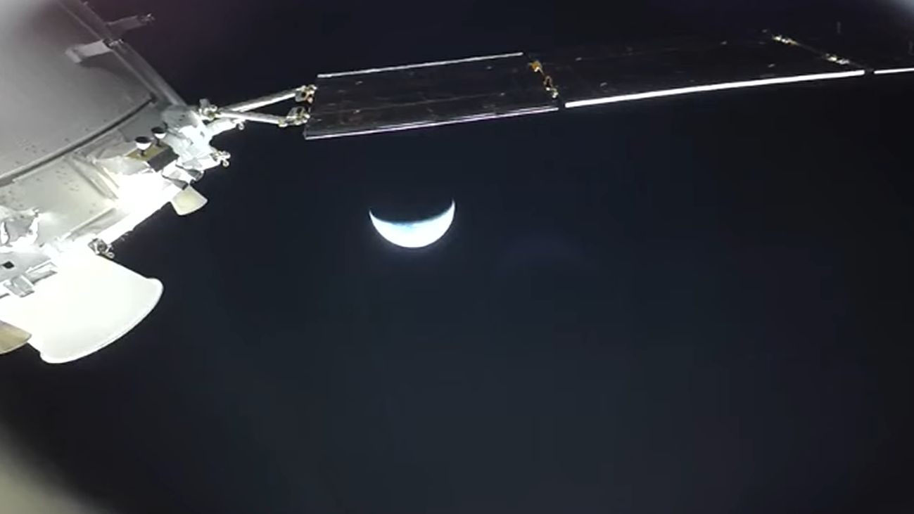 view of earth shining as bright crescent with part of orion visible above