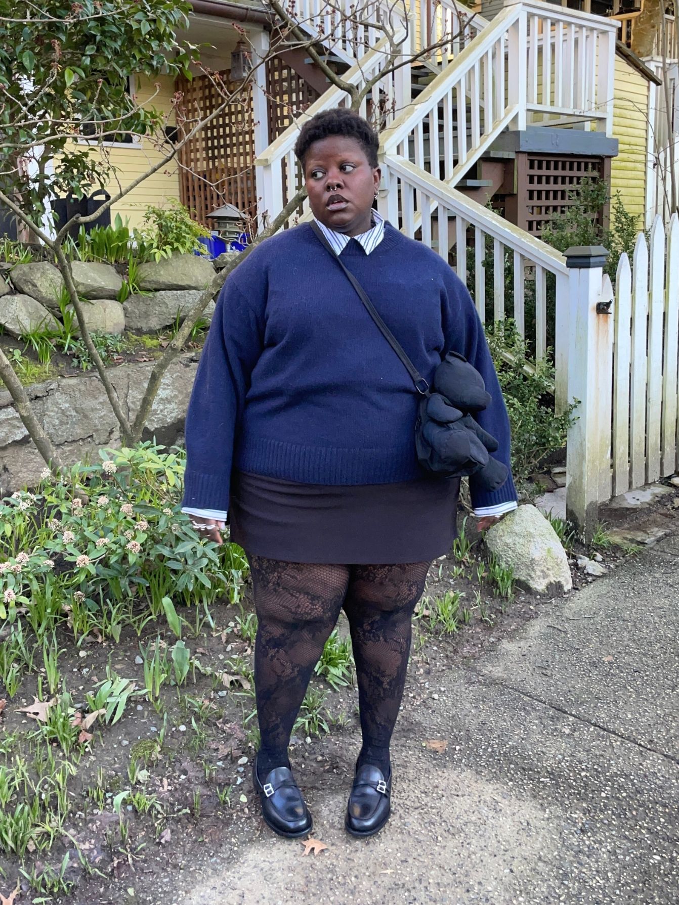 Lydia Okello styles a twee look with a tailored shirt under a crewneck, textured tights and loafers