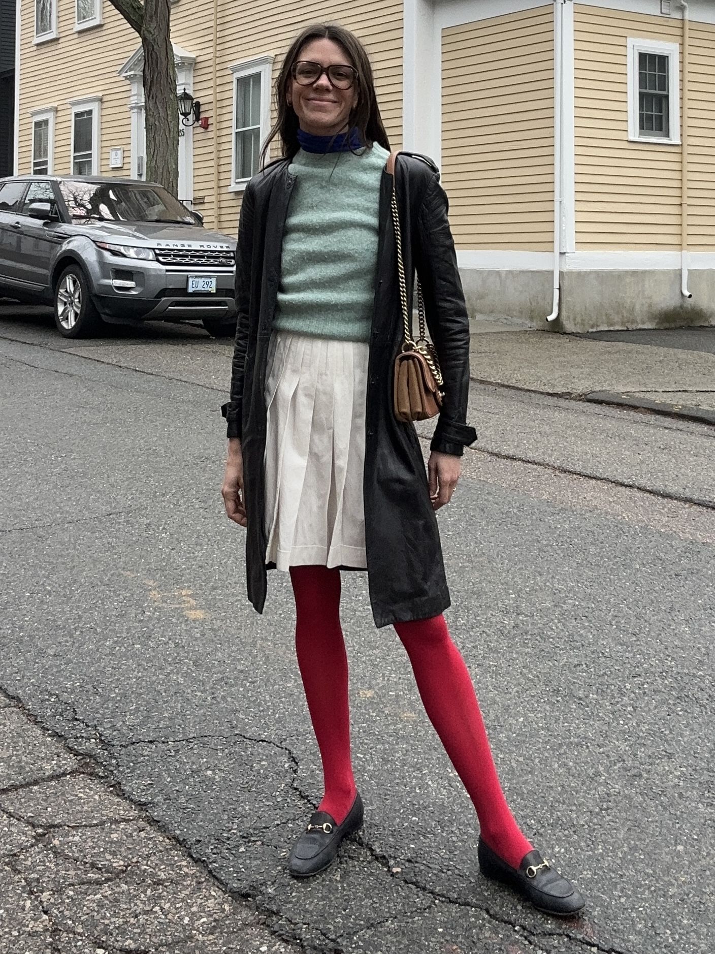 Julia Gall wears a pleated white mini skirt with red tights and a blue sweater