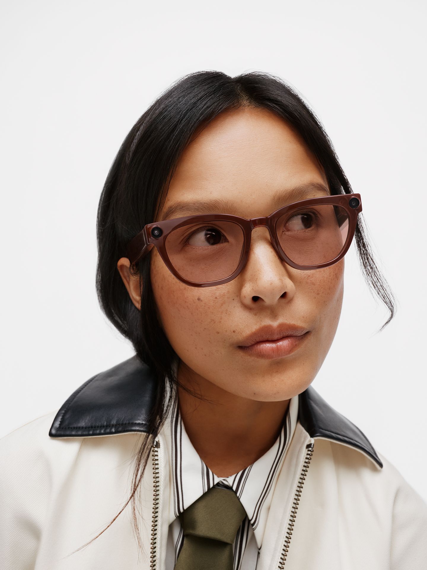 A model wearing brown translucent Warby Parker smart glasses with built-in cameras,