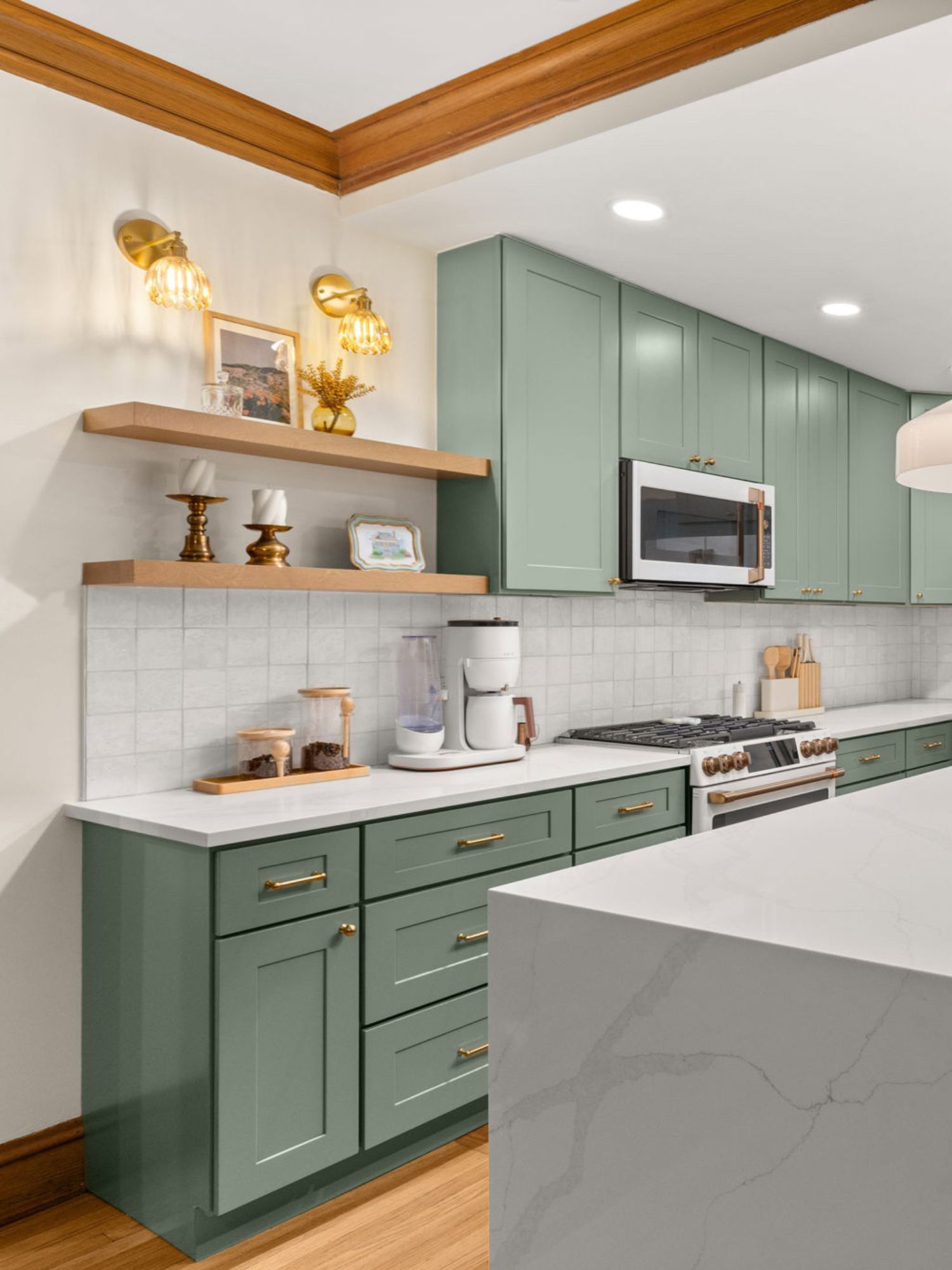 green kitchen cabinets with neutral walls and a marble island