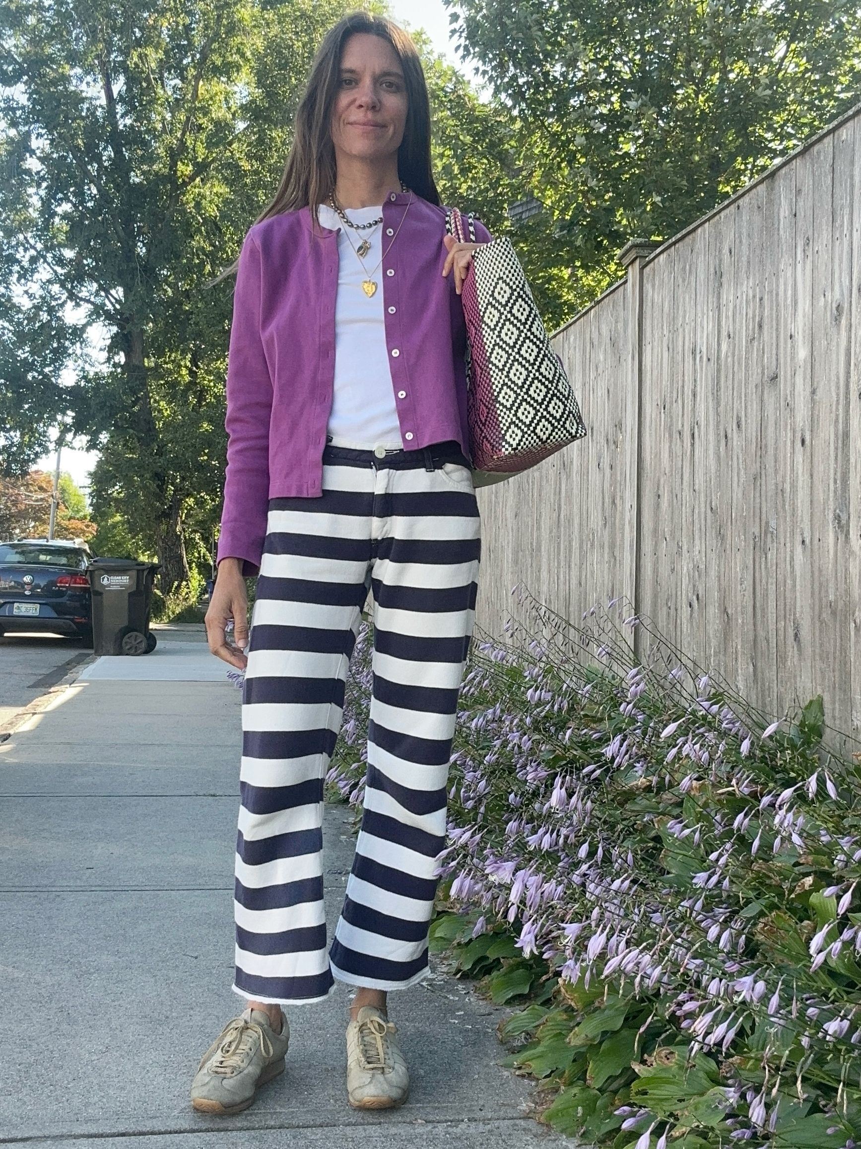 Julia Gall styles elevated striped sweatpants with a white shirt, sneakers and a purple cardigan