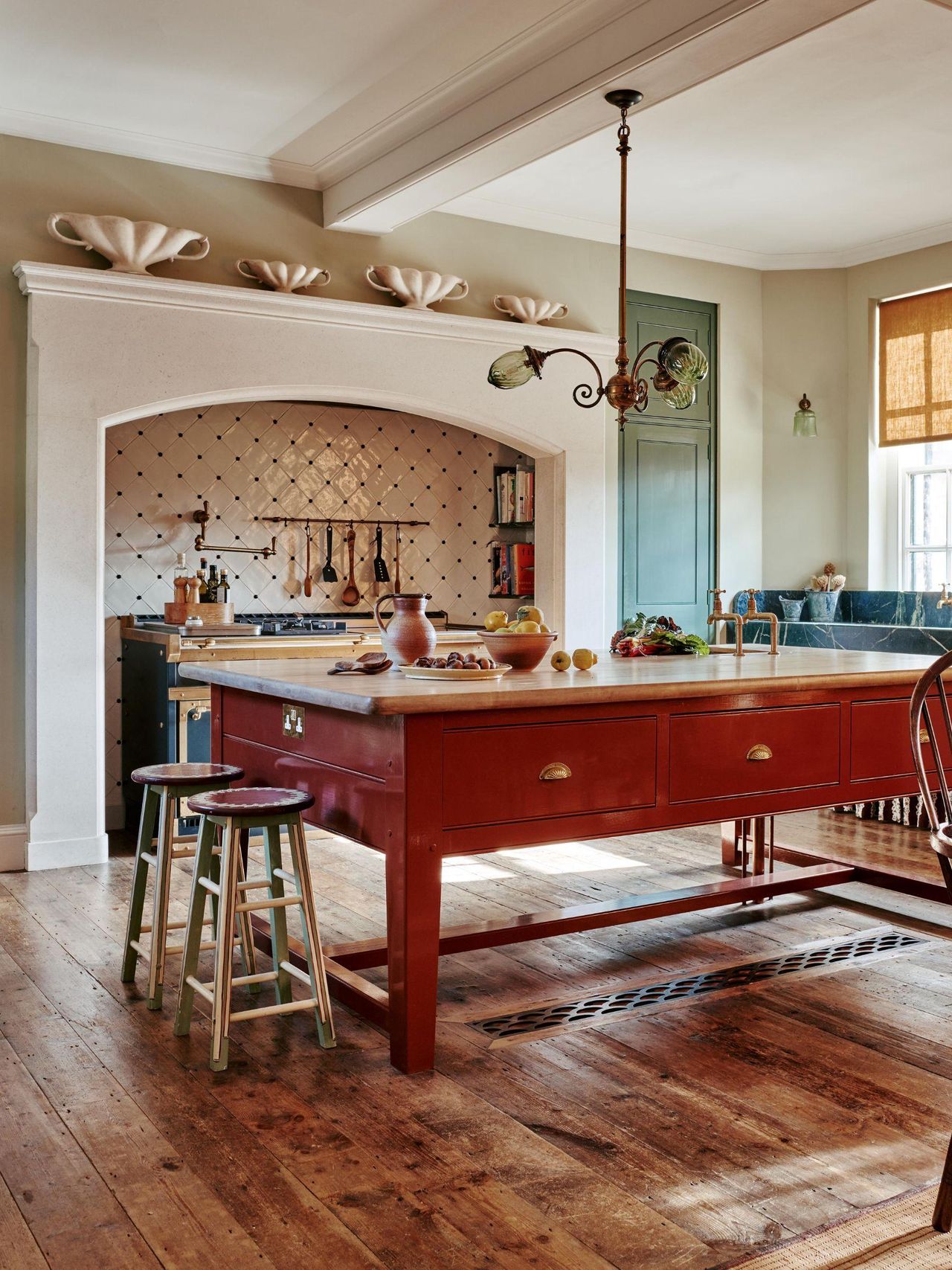 A traditional kitchen with a freestanding terracotta red island