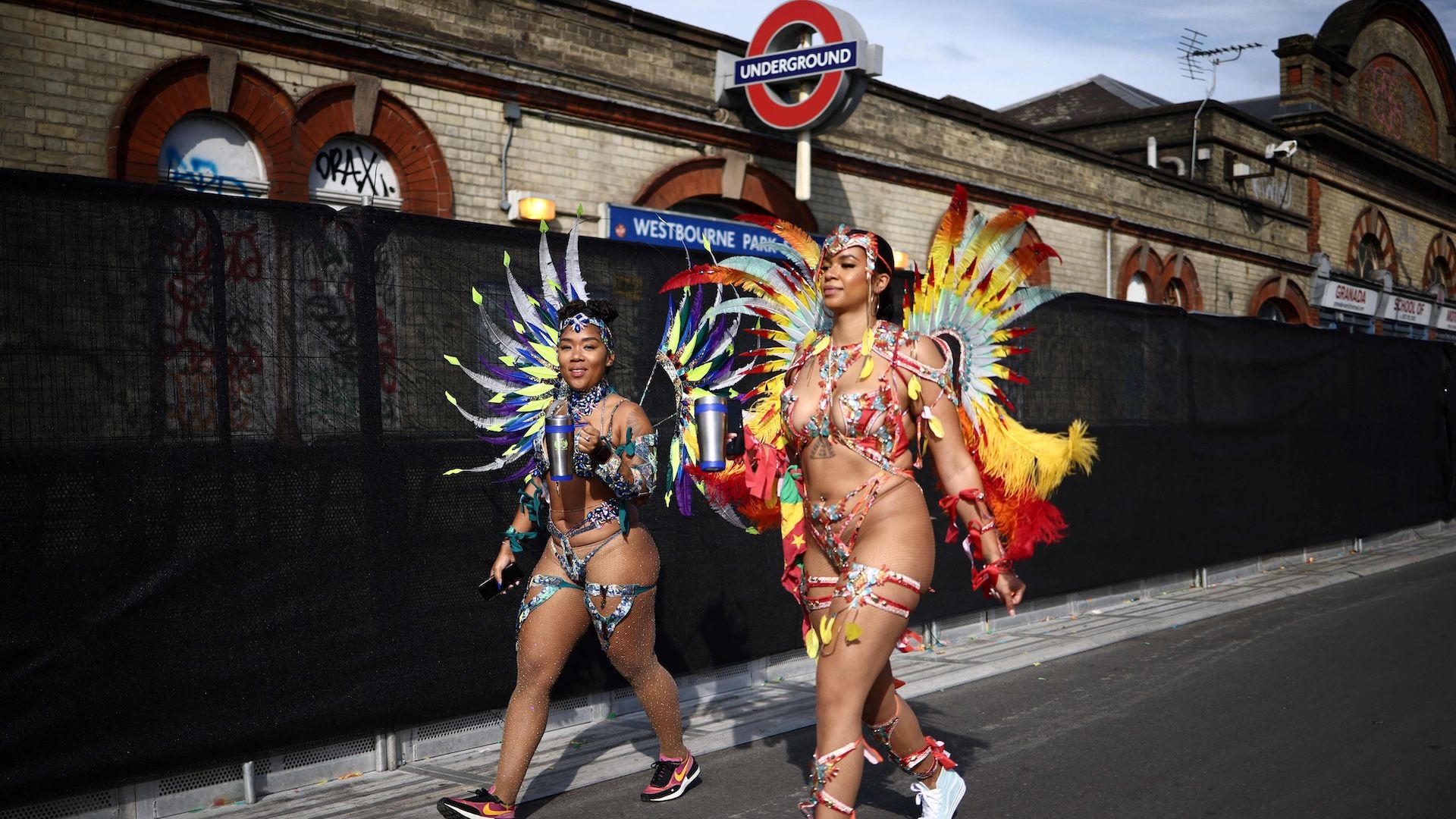 TOPSHOT - Performers in costume arrive to take part in the main Parade Day of the Notting Hill Carnival in west London on August 27, 2023. (Photo by HENRY NICHOLLS / AFP) (Photo by HENRY NICHOLLS/AFP via Getty Images)