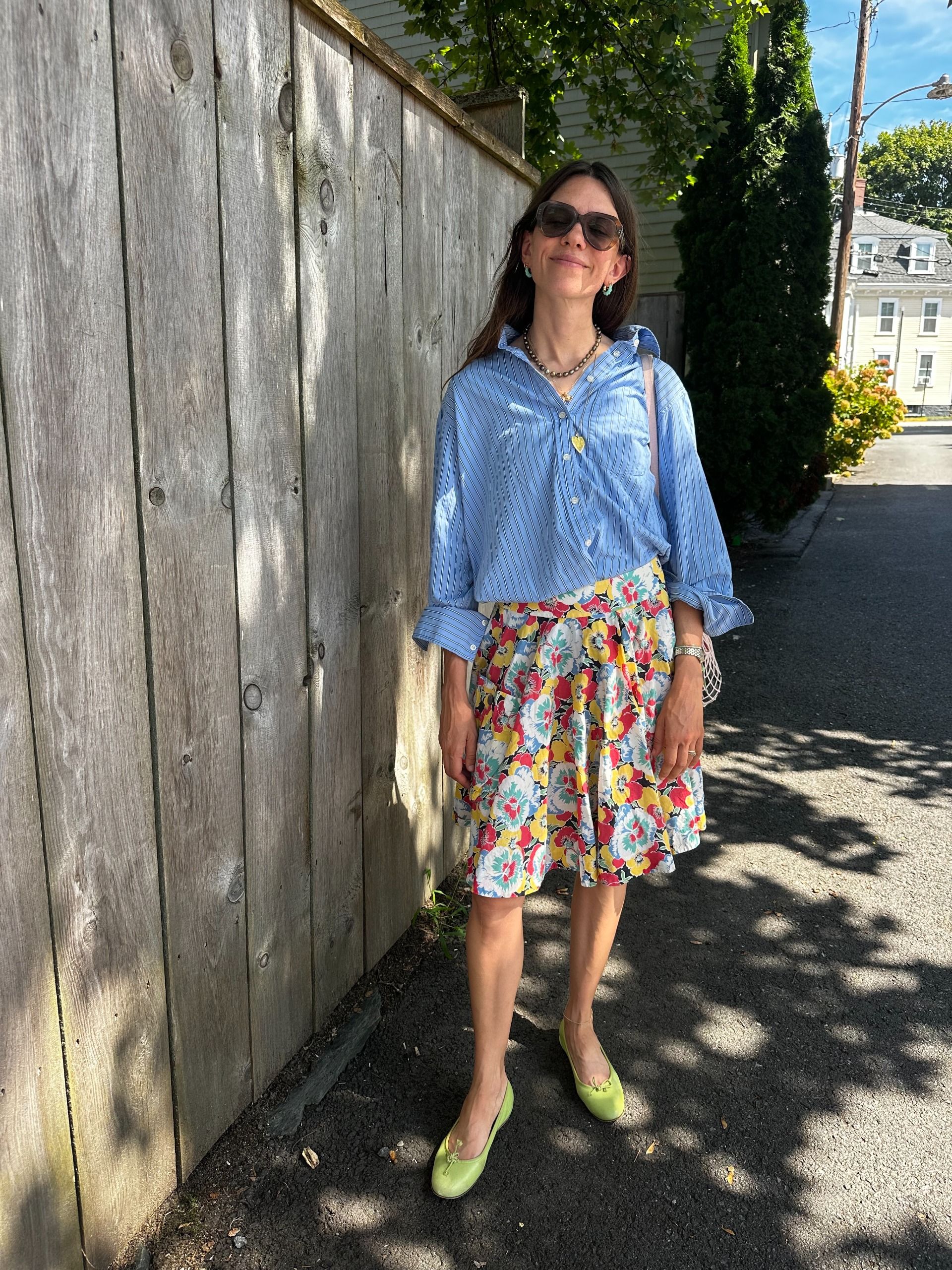 Julia Gall styles an oversized blue button-down with a short floral skirt and green ballet flats