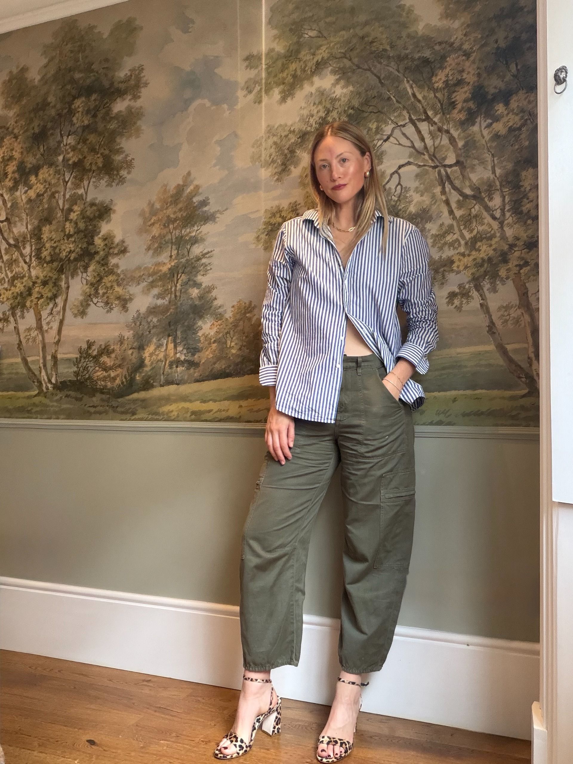 Brooke Ely Danielson styles mid heeled leopard print sandals with a striped button-down and olive cargo pants