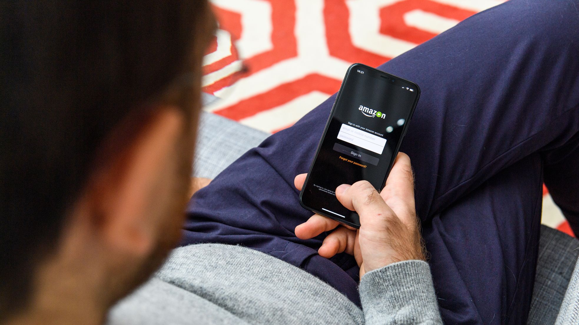 A man logs into Amazon on his phone.