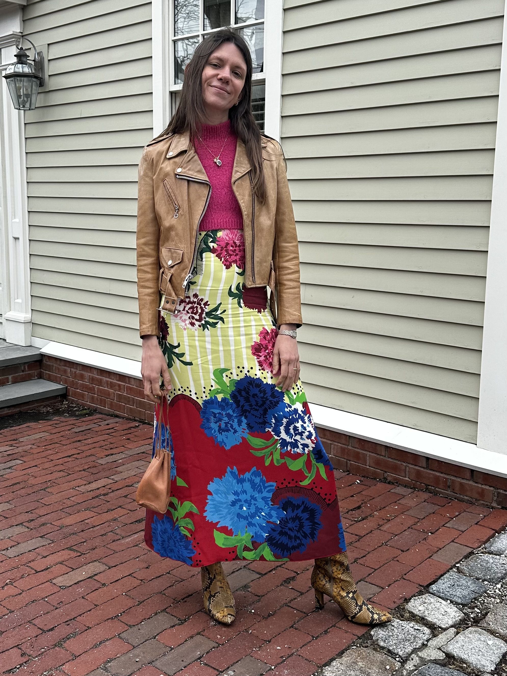 Julia Gall styles a drawstring pouch with a printed maxi dress, snakeskin boots, a leather jacket and hot pink sweater