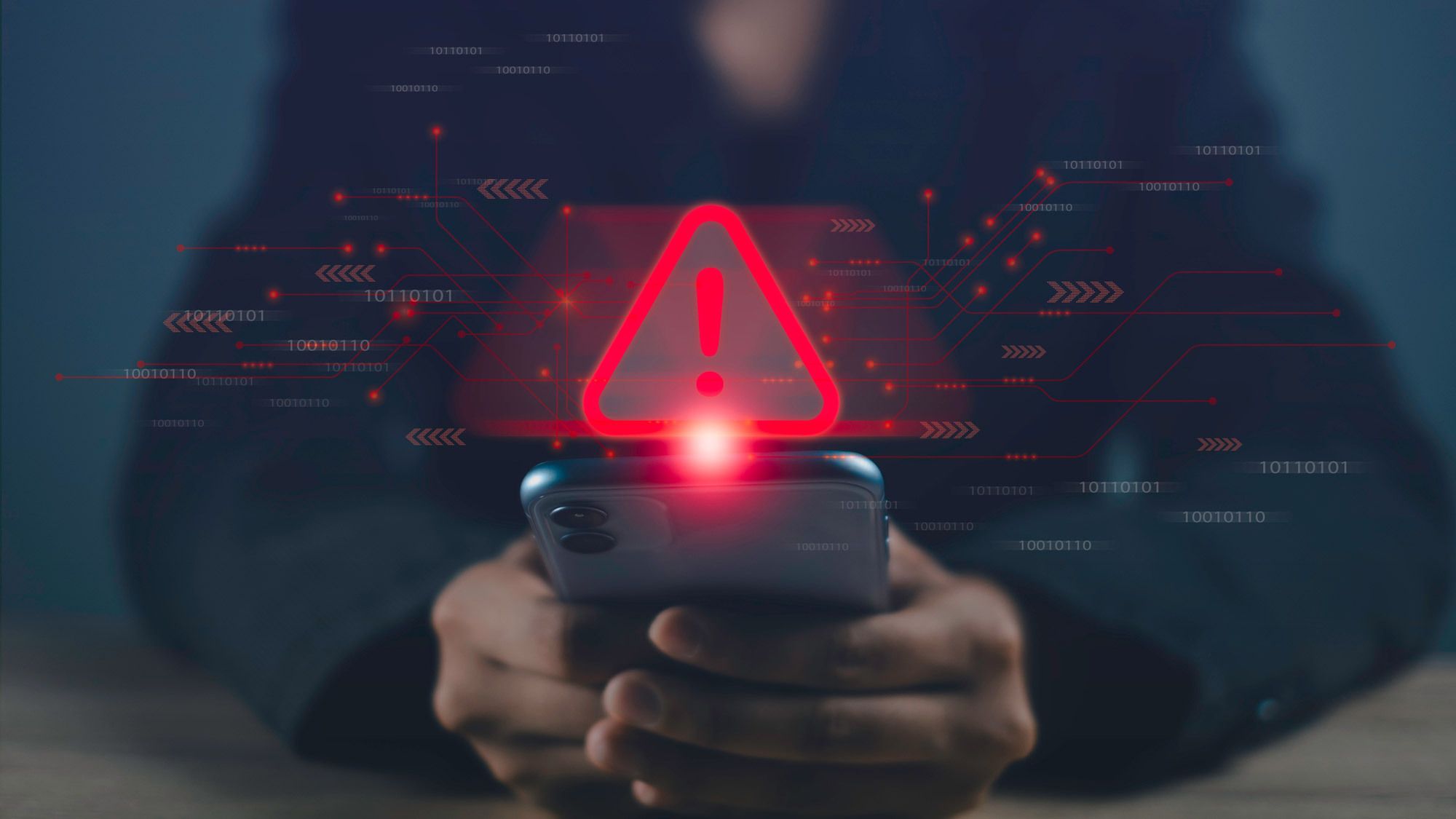 A person looking at a phone with a digital warning sign over it
