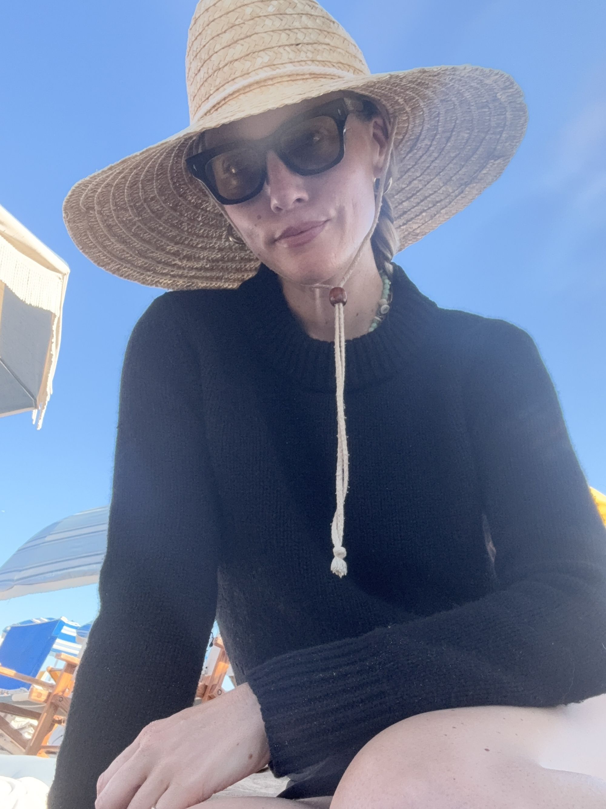 Brooke Ely Danielson pairs a straw sunhat with a black long sleeve