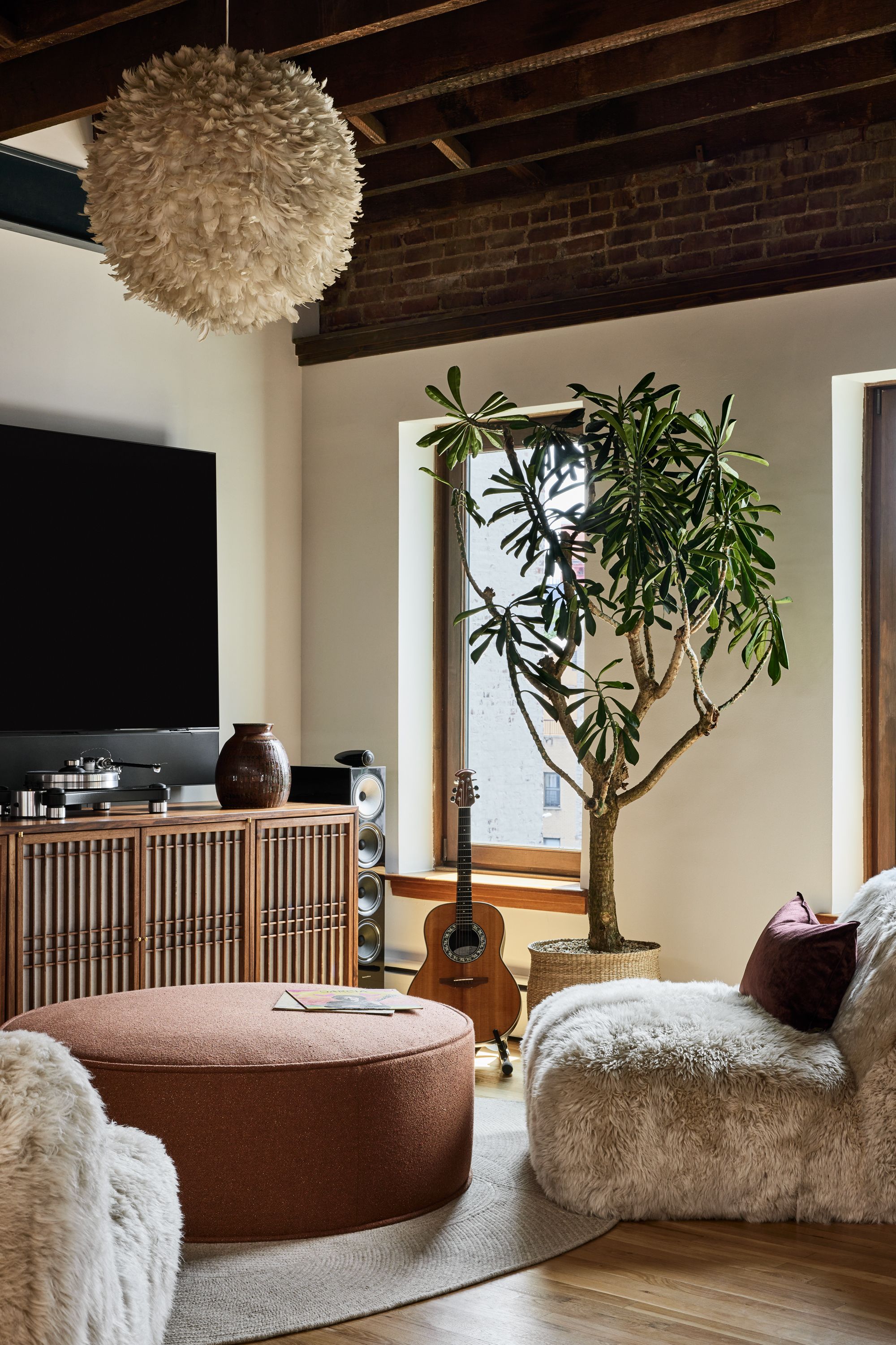 Feathered pendant light hanging in a eclectic, boho-style media room