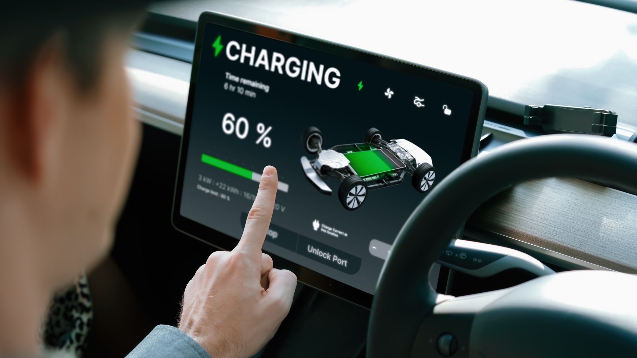 Electric car driver checks battery charging status, range and charging limit on app screen in the car.