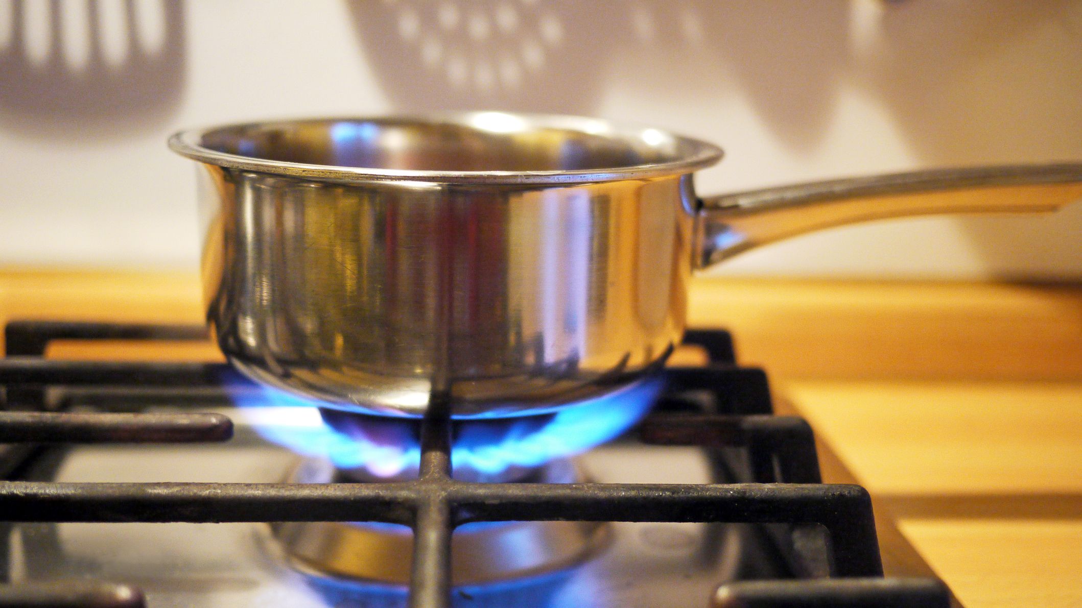 a cooking pot being warmed by a flame