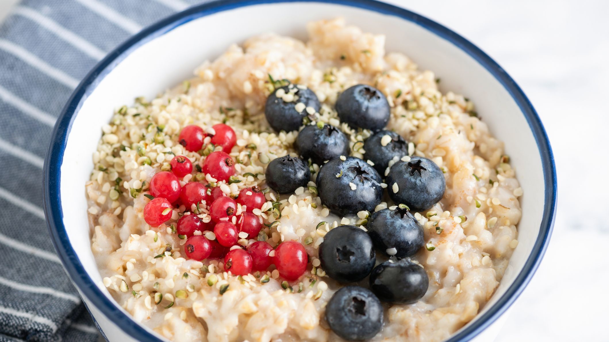 Bowl of porridge topped with berries and hemp seeds