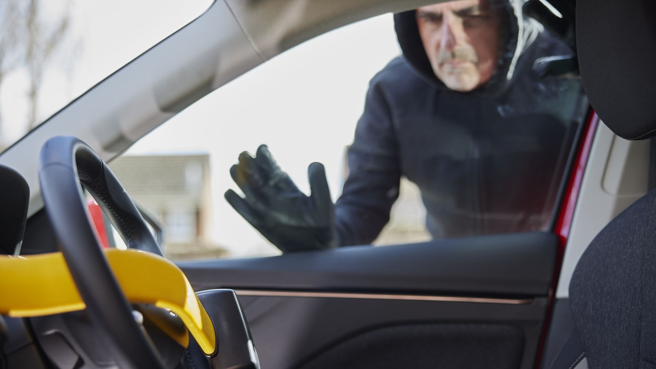a car thief examining a steering wheel lock