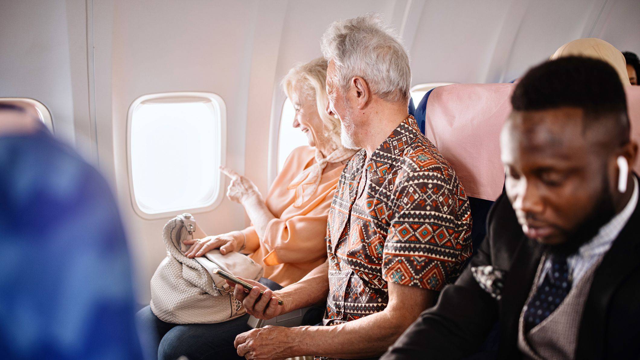 A senior couple sitting on an airplane.