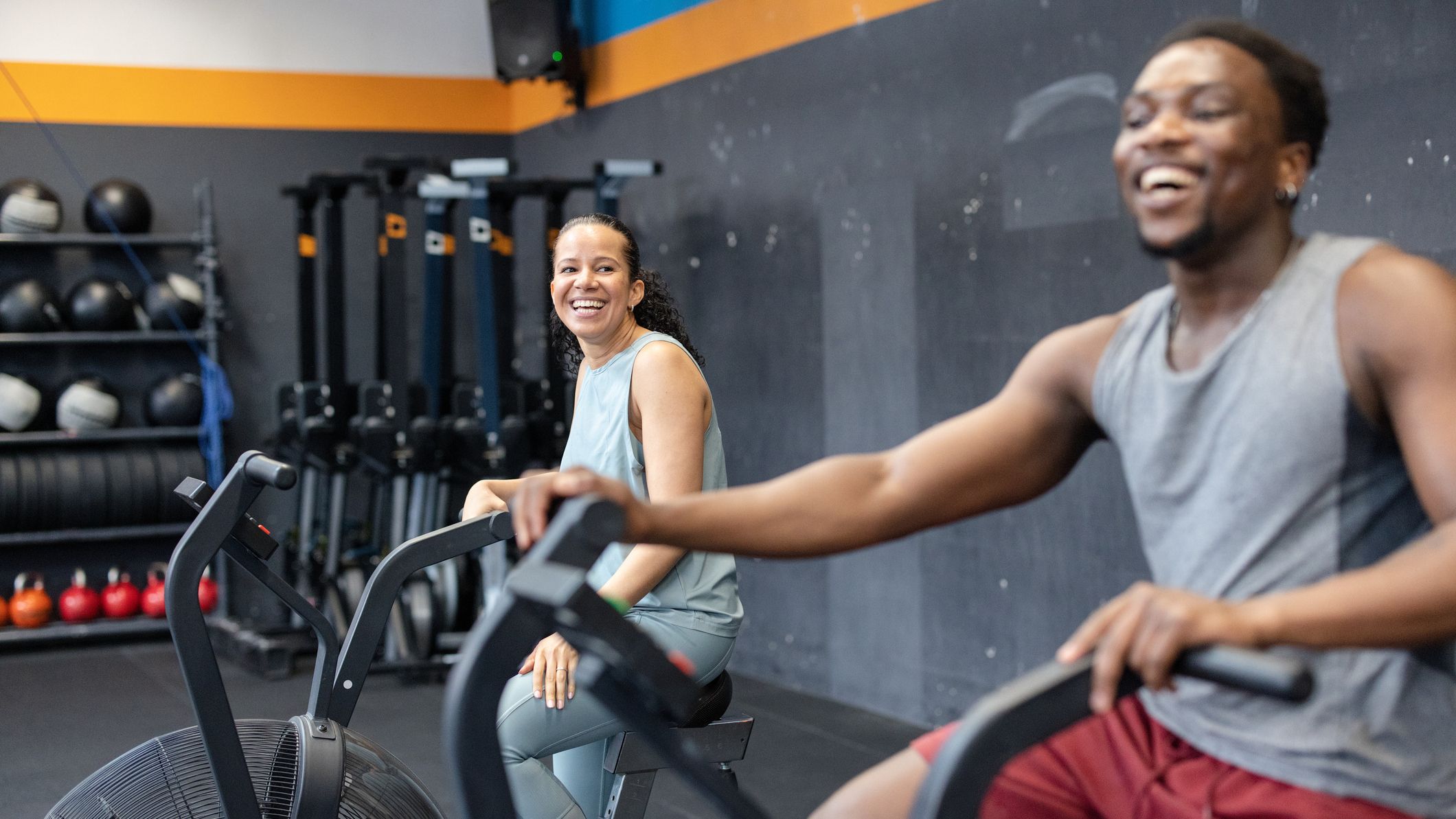 Two people on air bikes in the gym