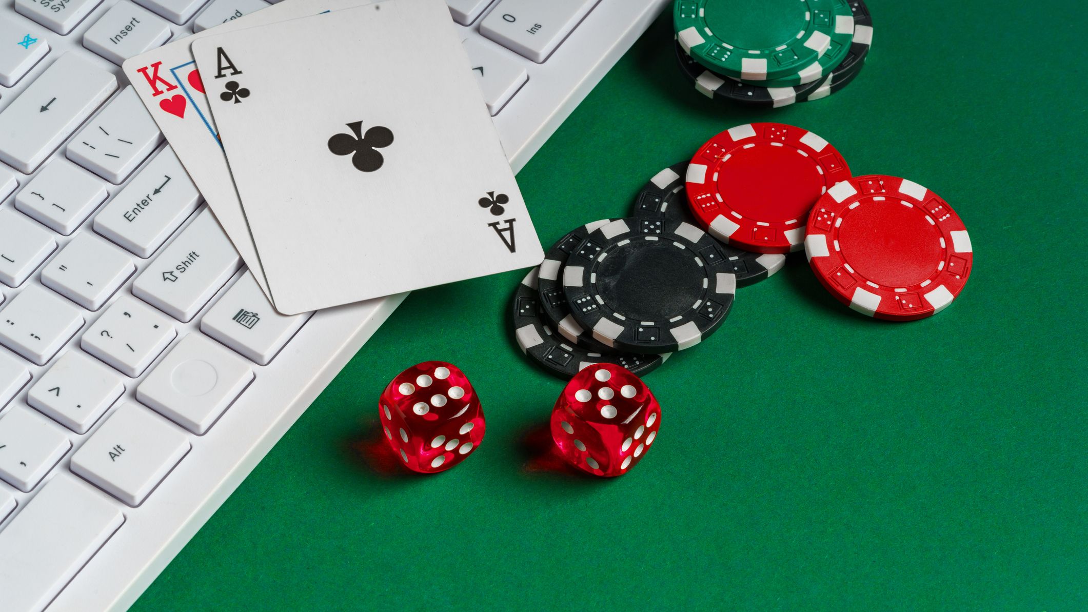 gambling board with poker chips, dice, cards, and a white keyboard