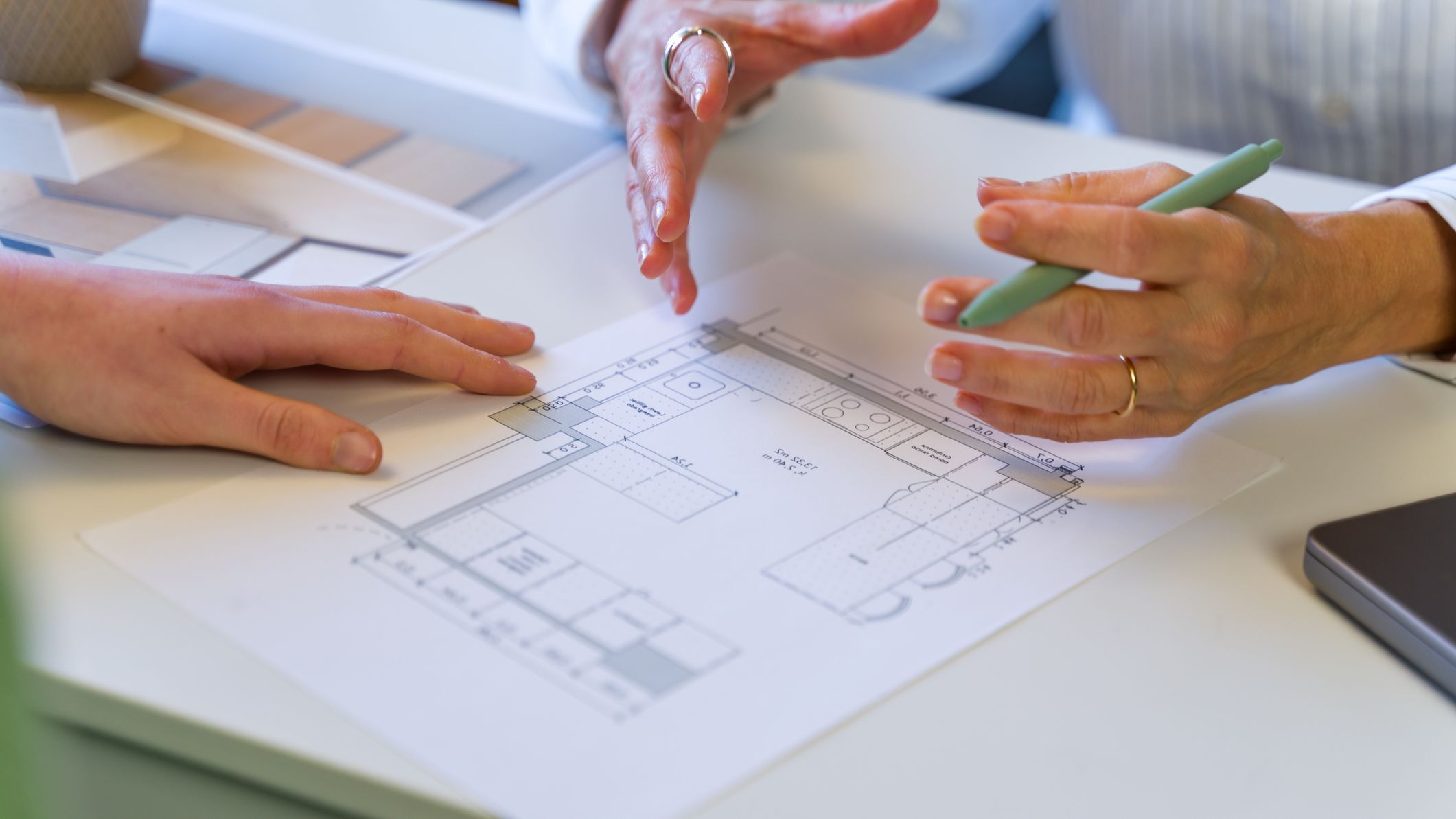 People discussing kitchen renovation blueprint and interior design plan