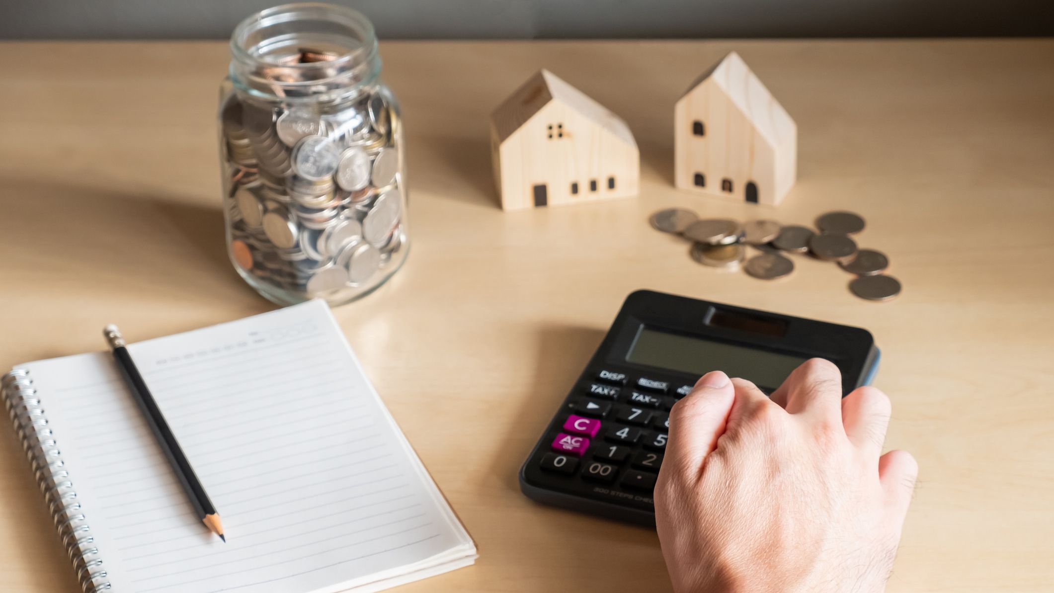 A hand using calculator to calculate saving plan
