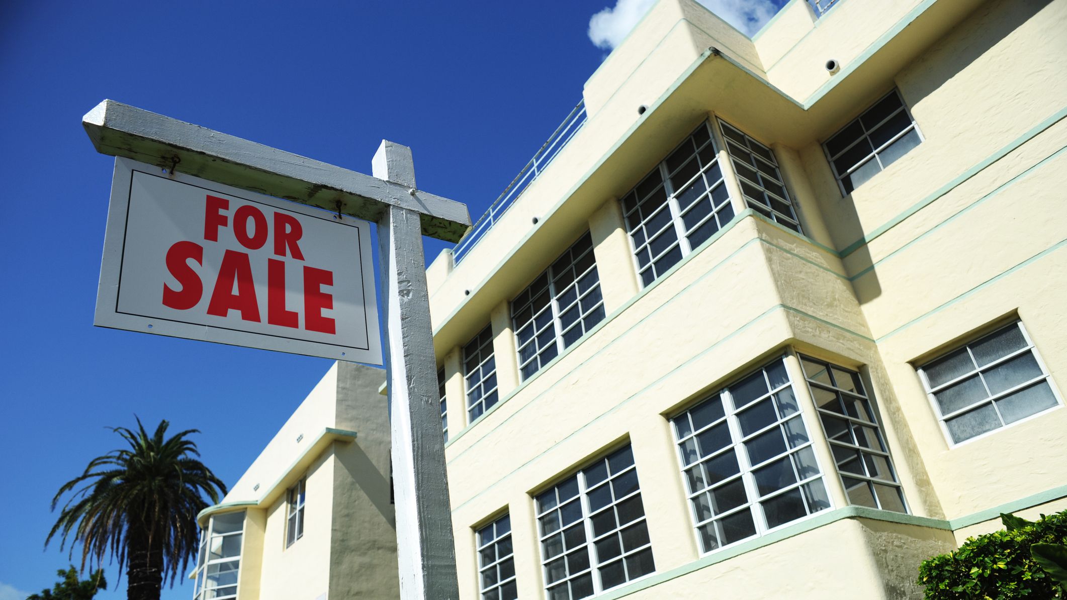 A condo with a For Sale sign outside.
