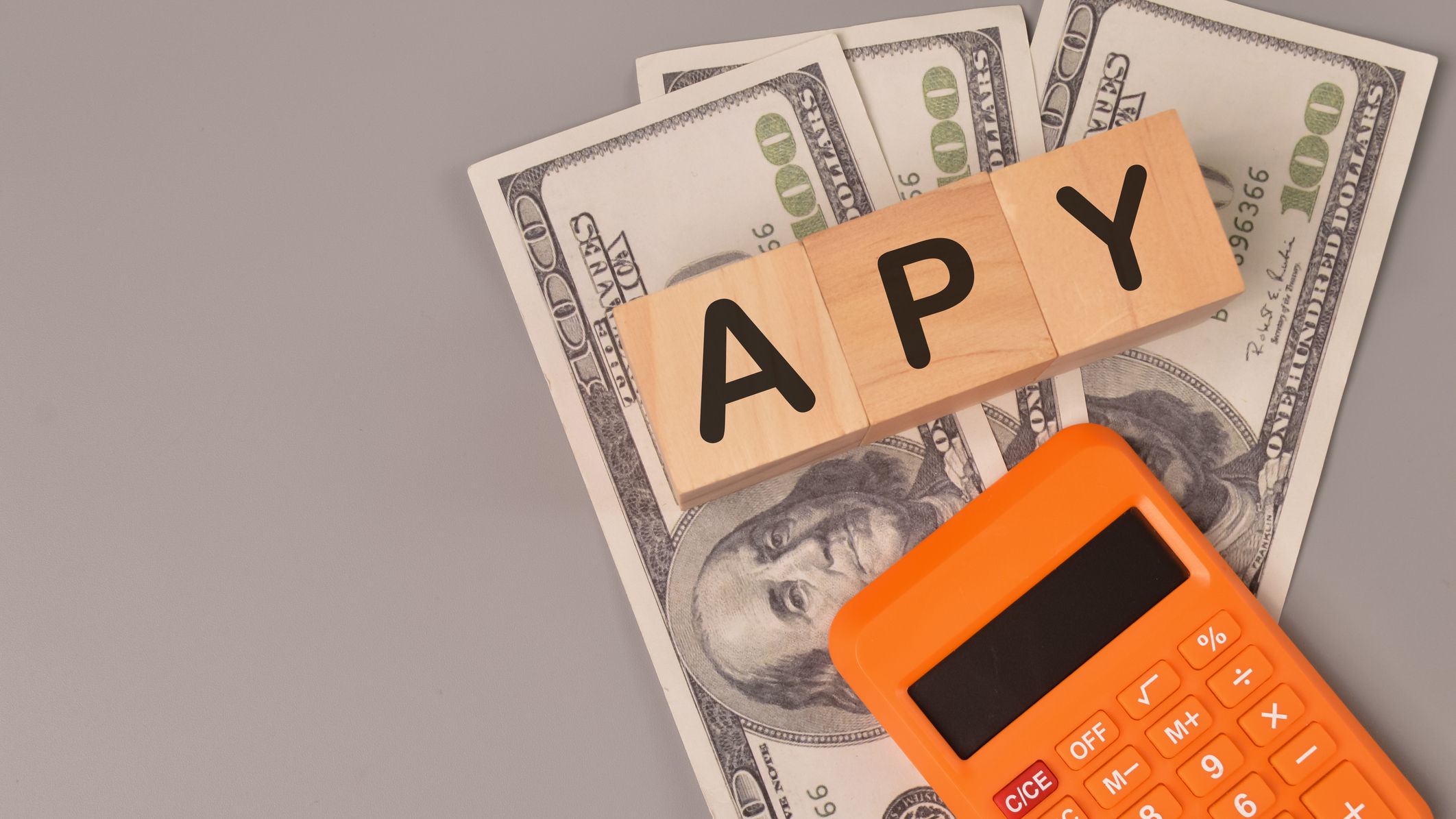 Money banknotes, calculator and wooden blocks written with APY.