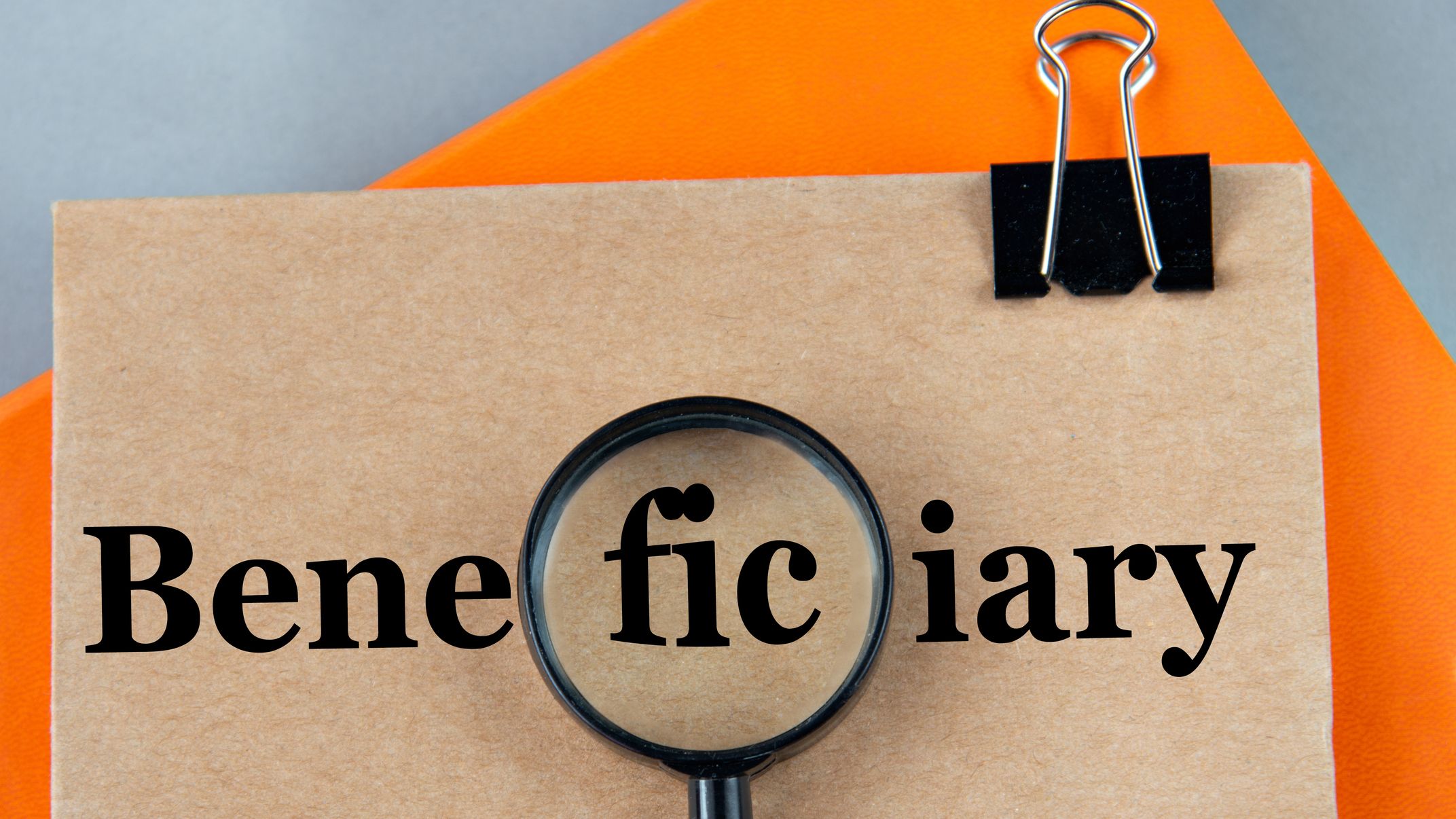 BENEFICIARY word on a brown sheet with a magnifying glass in the center