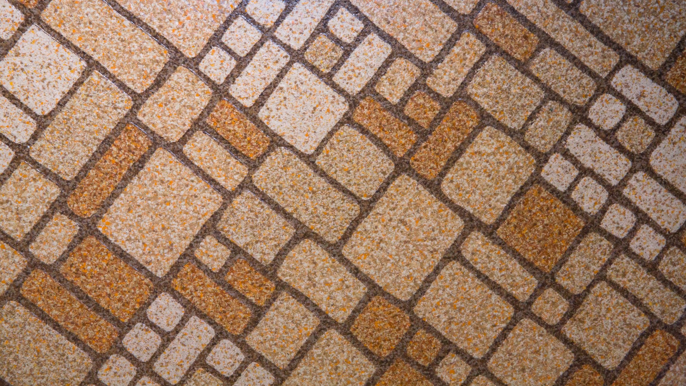 A close-up of a vintage linoleum floor. It's a 1970s brown-and-gold floor made of linoleum tiles.