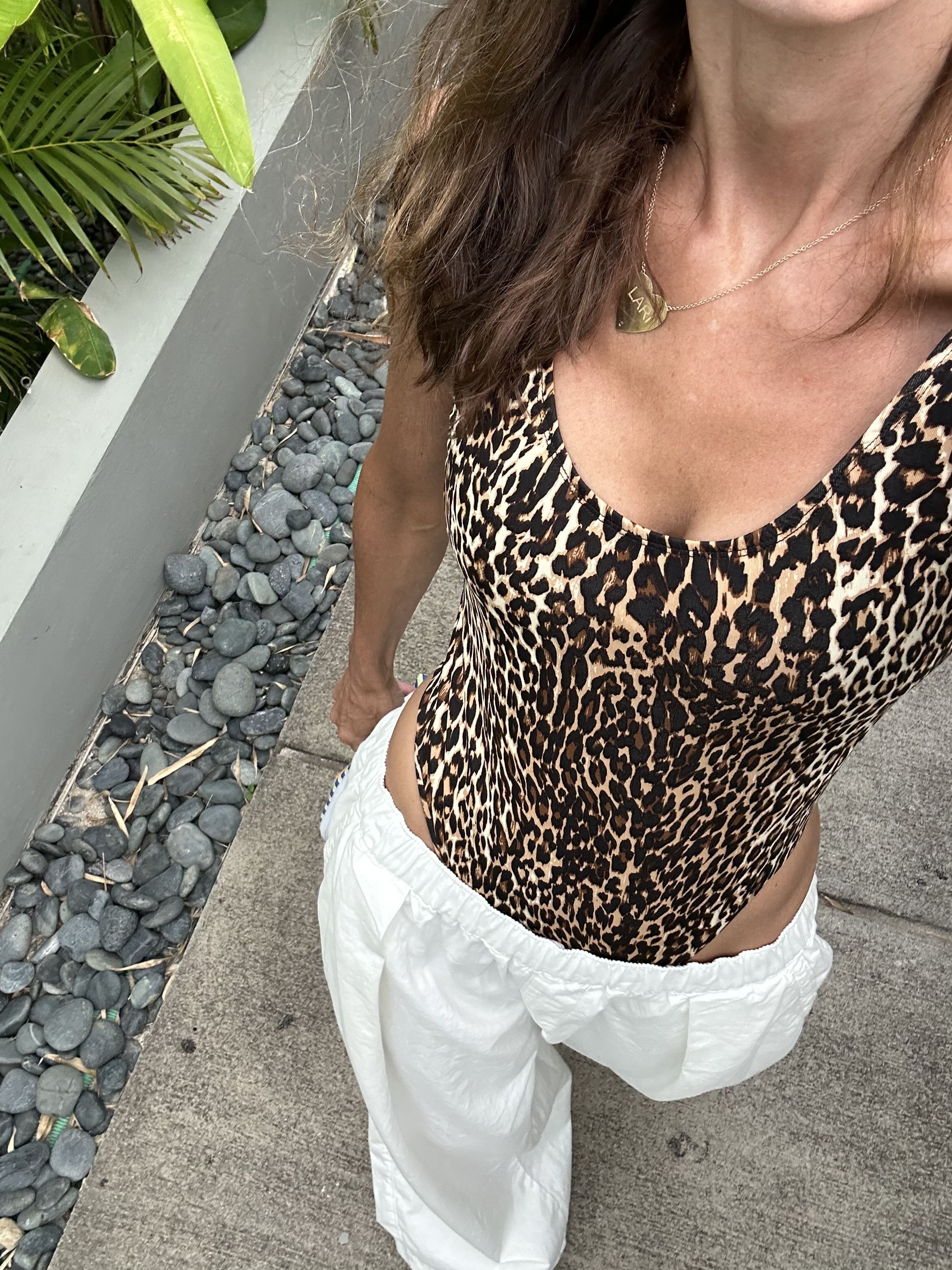 Larissa Mills wears a leopard print bodysuit and white pants