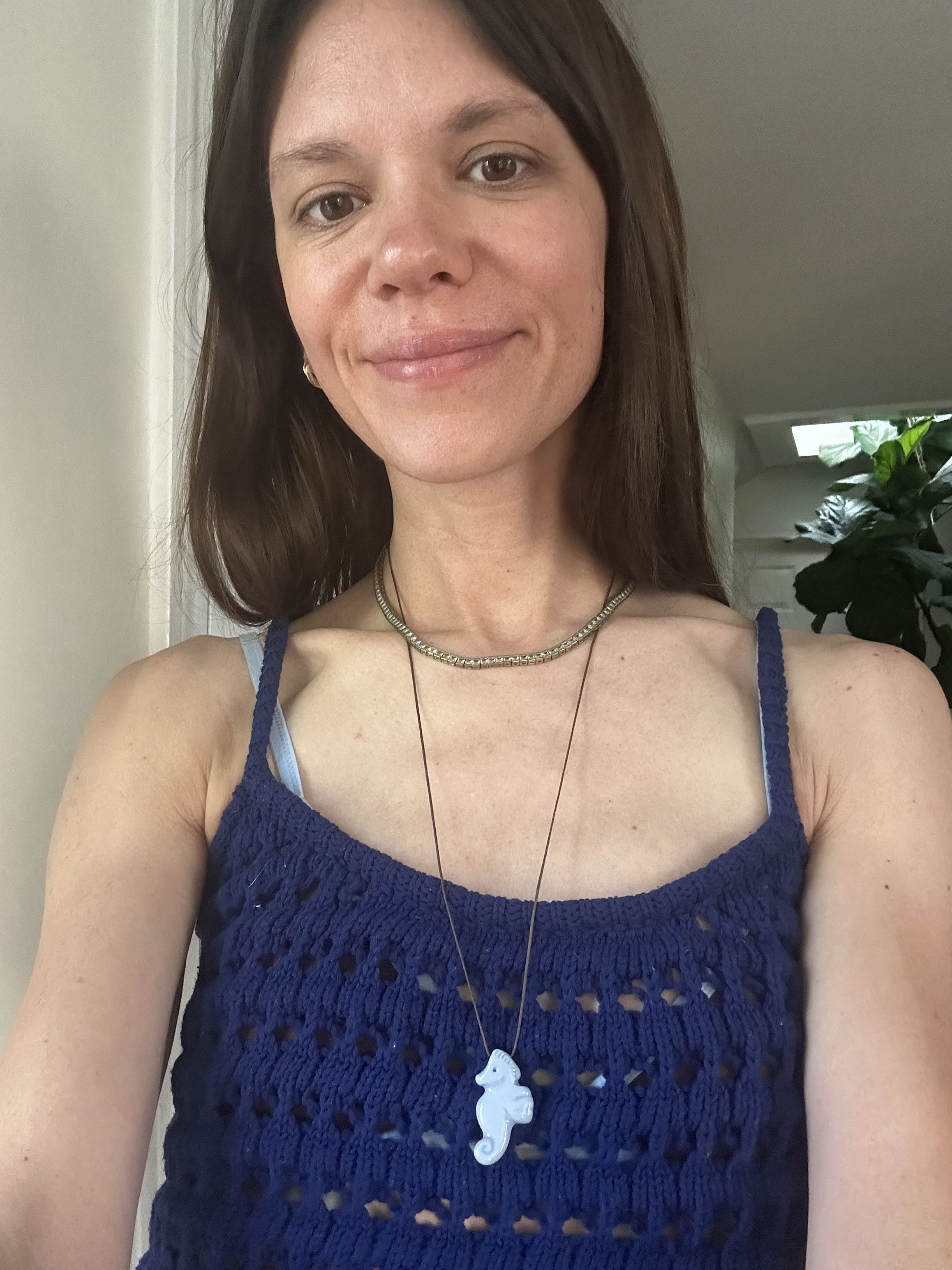 Julia Gall wears a playful ceramic seahorse pendant