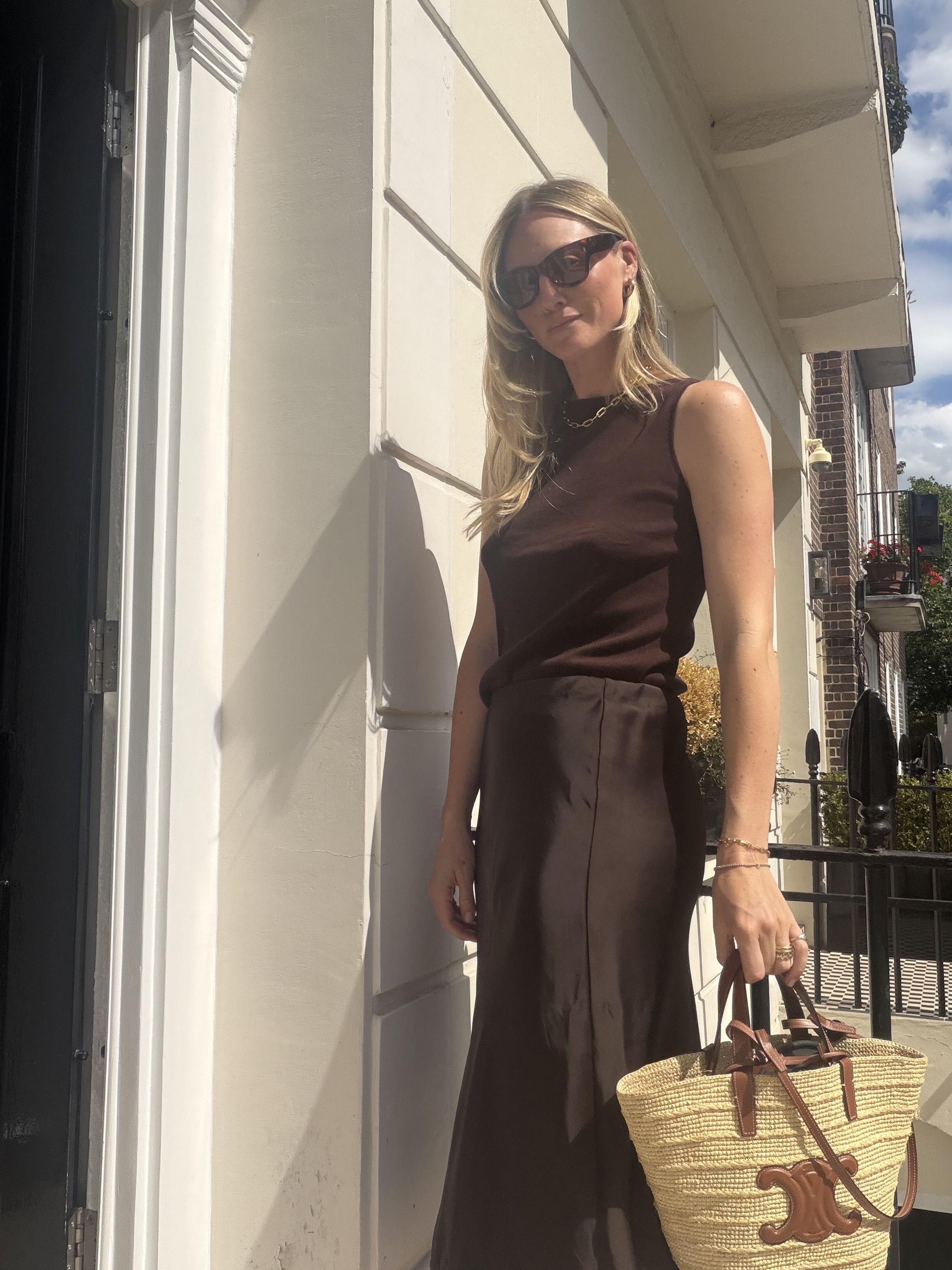 Brooke Ely Danielson wears a brown knit tank with a satin skirt and Celine woven bag